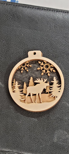 Laser cut wooden ornament with a forest and moose scene